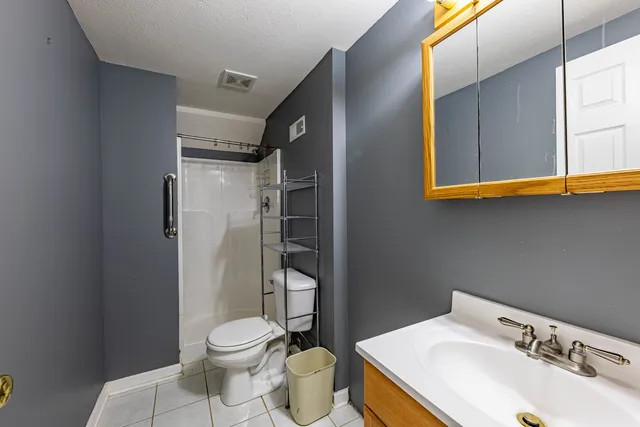 a kitchen with stainless steel appliances granite countertop a refrigerator a stove top oven a sink and dishwasher with wooden floor