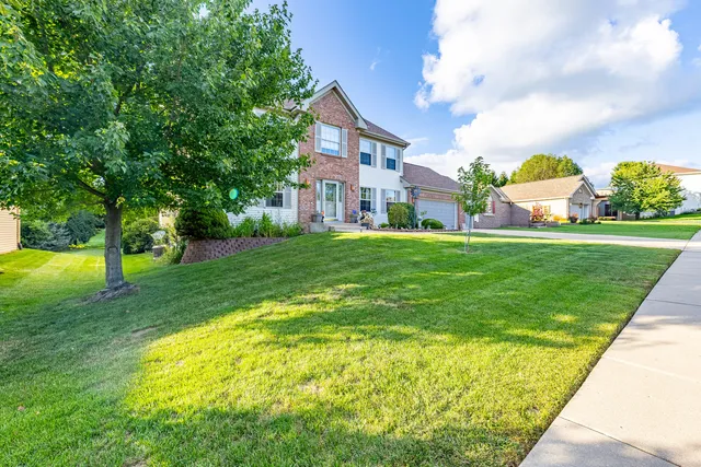 a view of a fountain in front of a house with a big yard