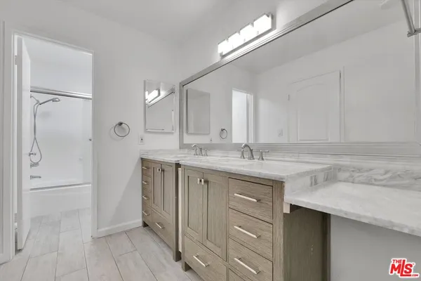 a bathroom with a sink a mirror and a shower