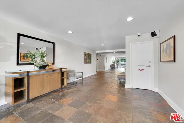 a large white kitchen with a refrigerator a stove a microwave and a dining table