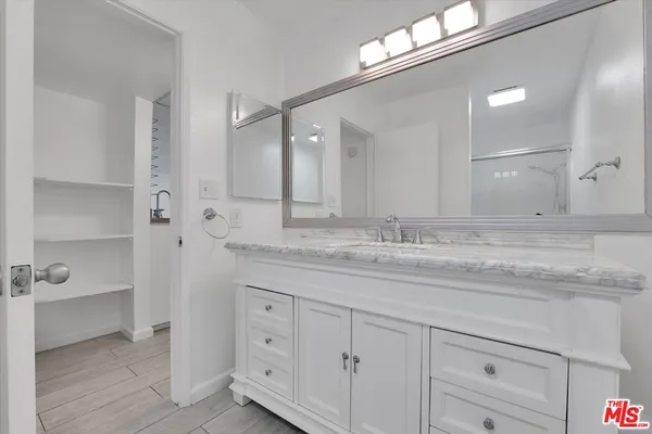 a bathroom with a granite countertop sink a toilet and a large mirror