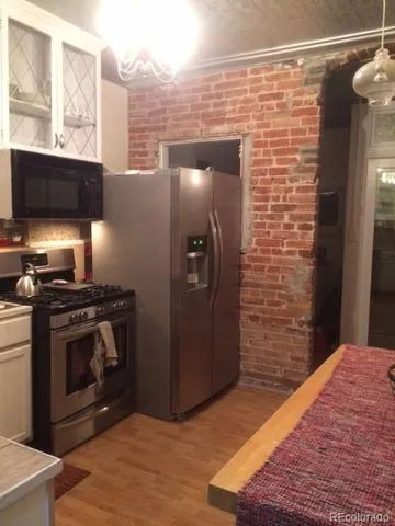 a kitchen with stainless steel appliances granite countertop a stove a refrigerator and a wooden cabinets