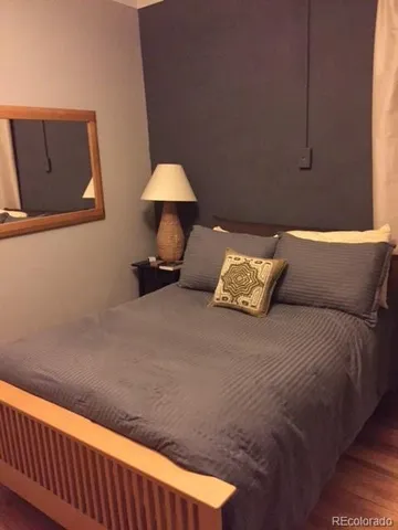 a bed sitting in a bedroom next to a lamp