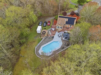 an aerial view of a house with swimming pool outdoor seating and yard