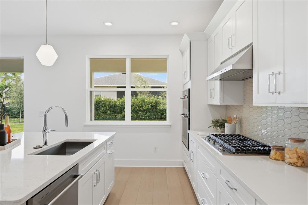 2430 Park Ridge Street Apopka, FL 32712 - Photo 16 of 49 a kitchen that has a lot of cabinets in it and a window