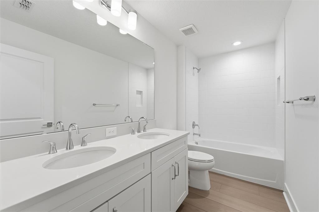 2430 Park Ridge Street Apopka, FL 32712 - Photo 28 of 49 a bathroom with a double vanity sink toilet mirror and shower