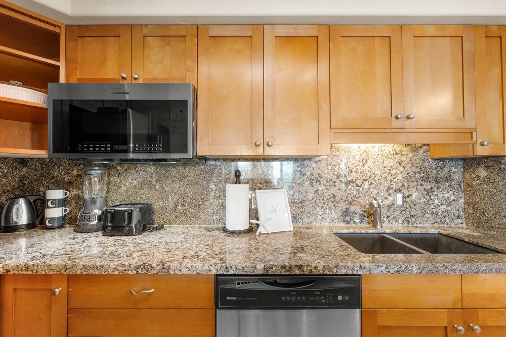 4327 Lower Honoapiilani Road, Unit 403 Lahaina, HI 96761 - Photo 11 of 42 a kitchen with granite countertop a sink a stove and cabinets