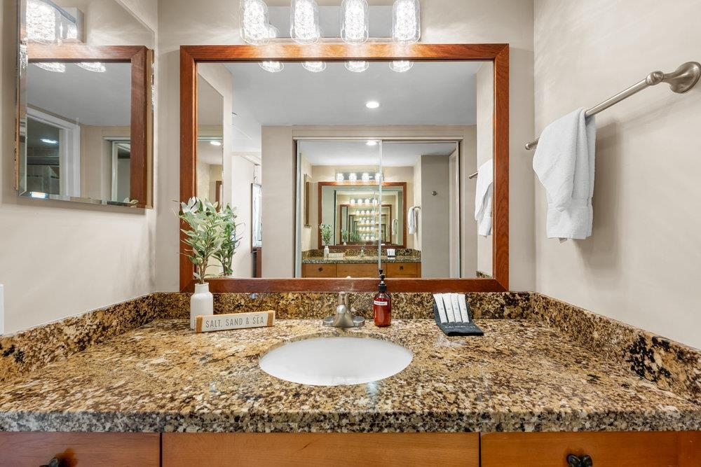 4327 Lower Honoapiilani Road, Unit 403 Lahaina, HI 96761 - Photo 19 of 42 a bathroom with a granite countertop sink and a mirror