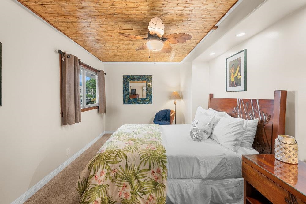 4327 Lower Honoapiilani Road, Unit 403 Lahaina, HI 96761 - Photo 21 of 42 a bedroom with a bed and a chandelier