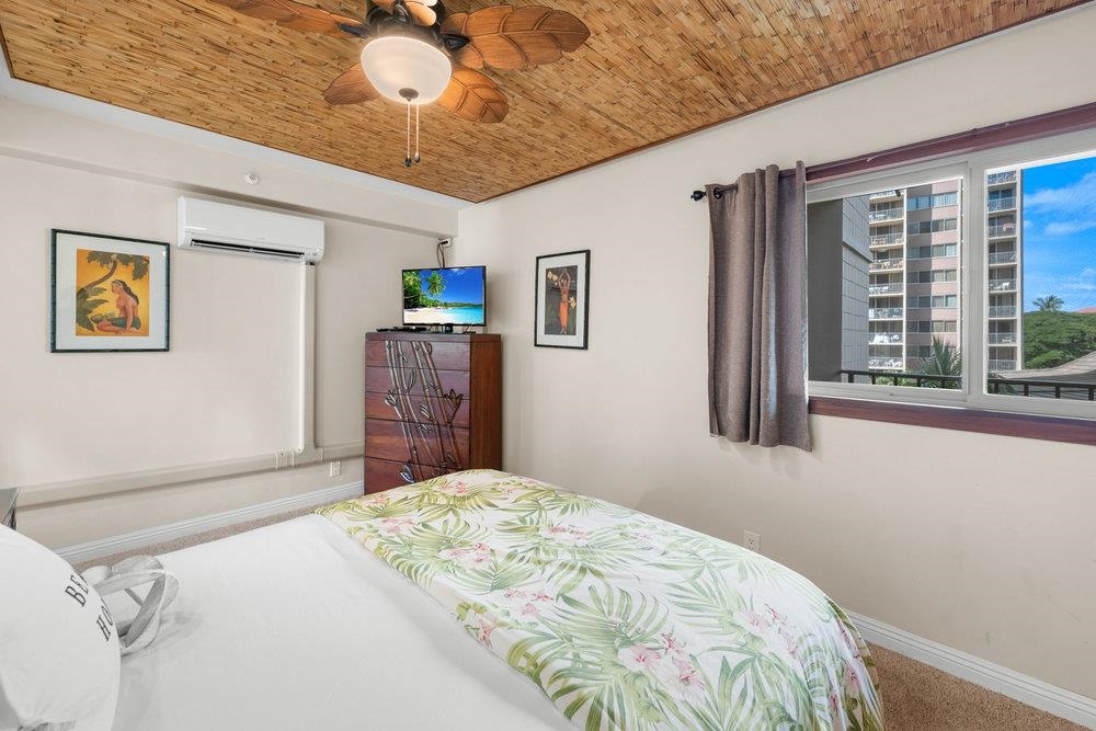 4327 Lower Honoapiilani Road, Unit 403 Lahaina, HI 96761 - Photo 23 of 42 a bedroom with a bed and a chandelier