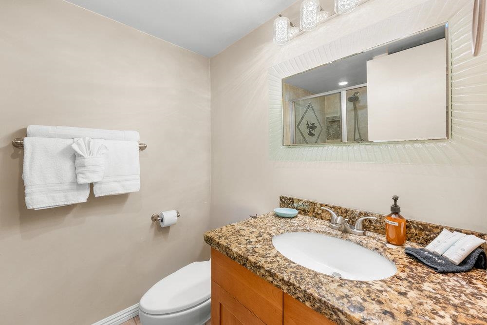 4327 Lower Honoapiilani Road, Unit 403 Lahaina, HI 96761 - Photo 25 of 42 a bathroom with a granite countertop sink mirror vanity and toilet