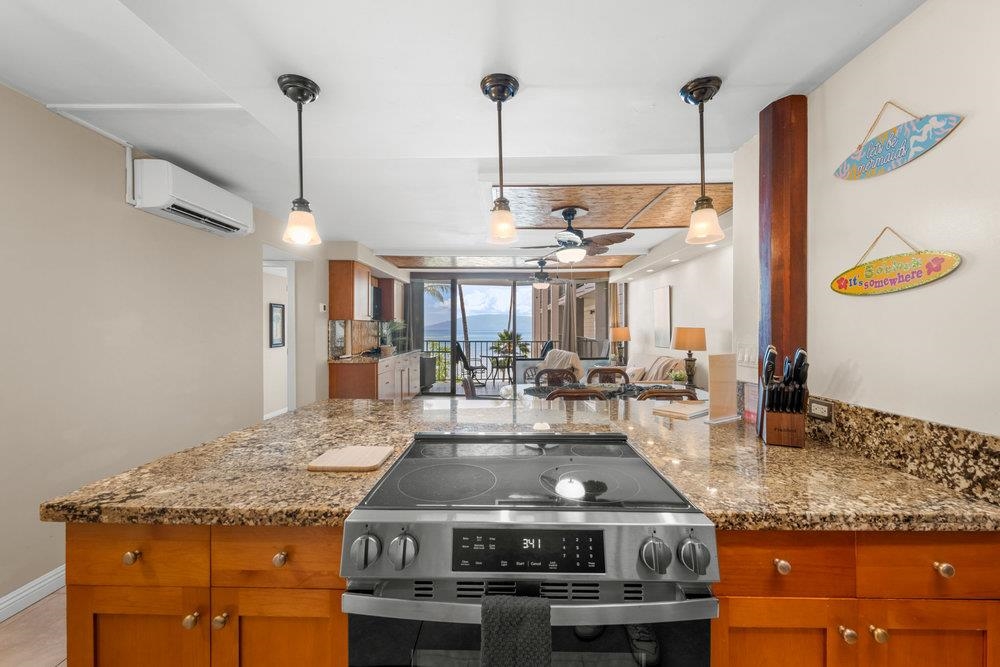 4327 Lower Honoapiilani Road, Unit 403 Lahaina, HI 96761 - Photo 9 of 42 a kitchen with kitchen island granite countertop a stove and a sink