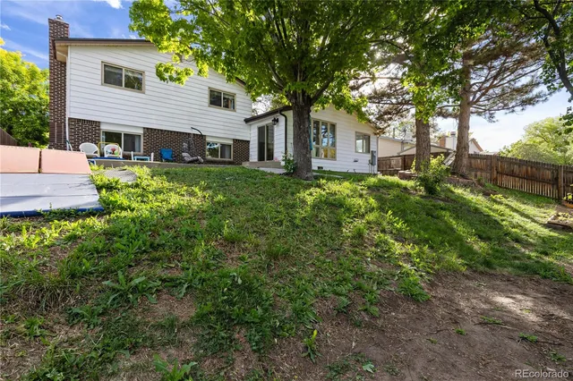 a front view of a house with a yard and trees