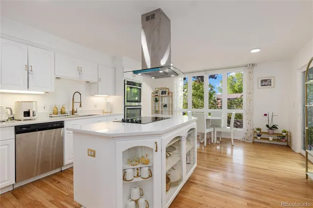 a very nice looking kitchen with granite countertop a stove and wooden floor