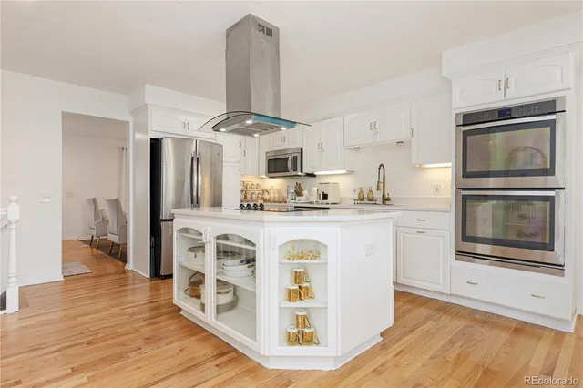 a kitchen with stainless steel appliances granite countertop a refrigerator a stove and a wooden floors