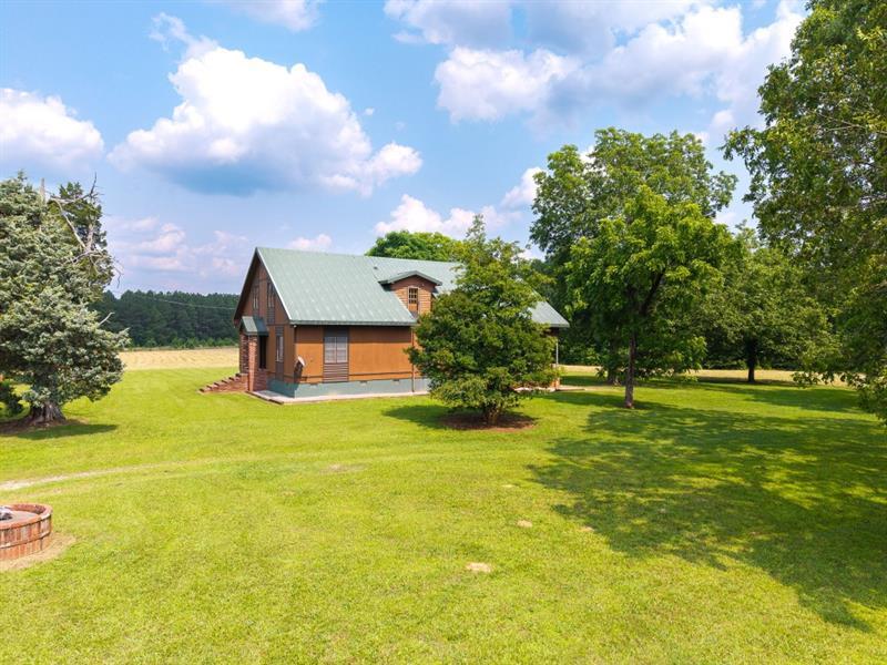 a front view of a house with a big yard and a large tree