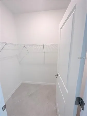 an empty room with windows and ceiling fan