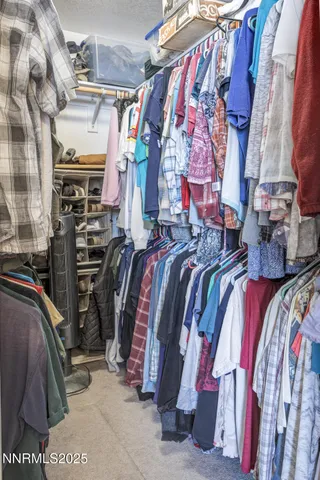 a view of walk in closet with clothes