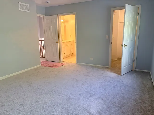 an empty room with windows and bathroom view