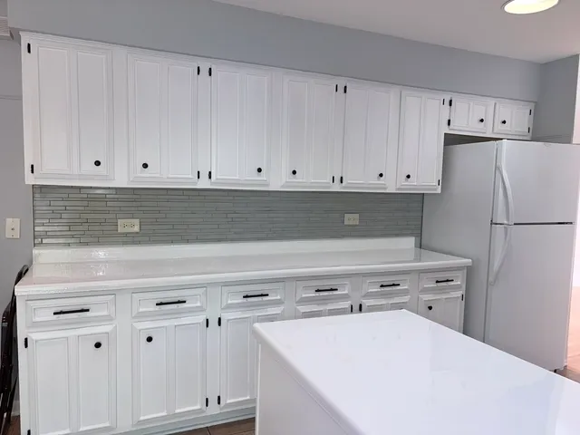 a kitchen with white cabinets and white appliances