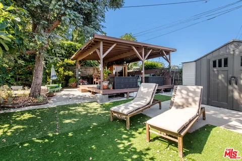 a view of a patio with table and chairs under an umbrella