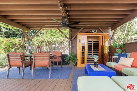 a porch area with table and chairs