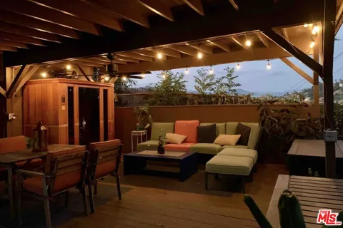 a outdoor living room with furniture and a floor to ceiling window