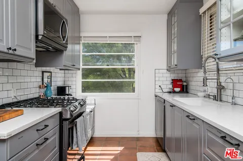 a kitchen with stainless steel appliances a stove a sink and a microwave