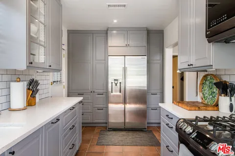 a kitchen with stainless steel appliances granite countertop a refrigerator a stove and a sink