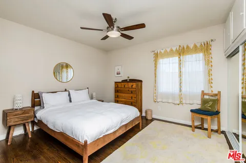 a bedroom with a bed a chandelier and a window