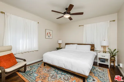 a bedroom with a bed a couch and a window