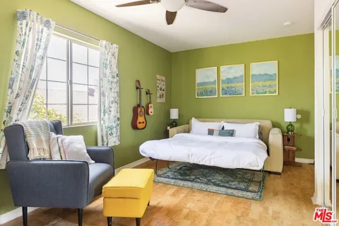 a bedroom with a bed a couch and a window