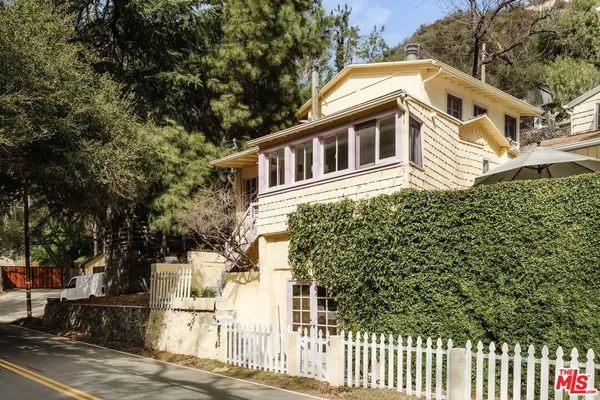 a front view of a house with a garden