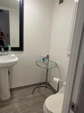 a bathroom with a sink a toilet and mirror