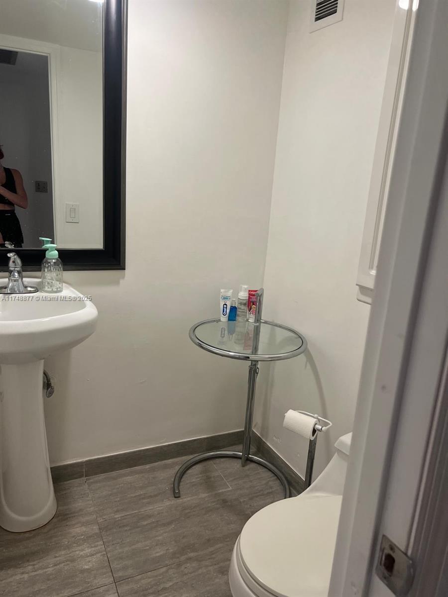2750 Northeast 183rd Street, Unit 801 Aventura, FL 33160 - Photo 11 of 29 a bathroom with a sink a toilet and mirror
