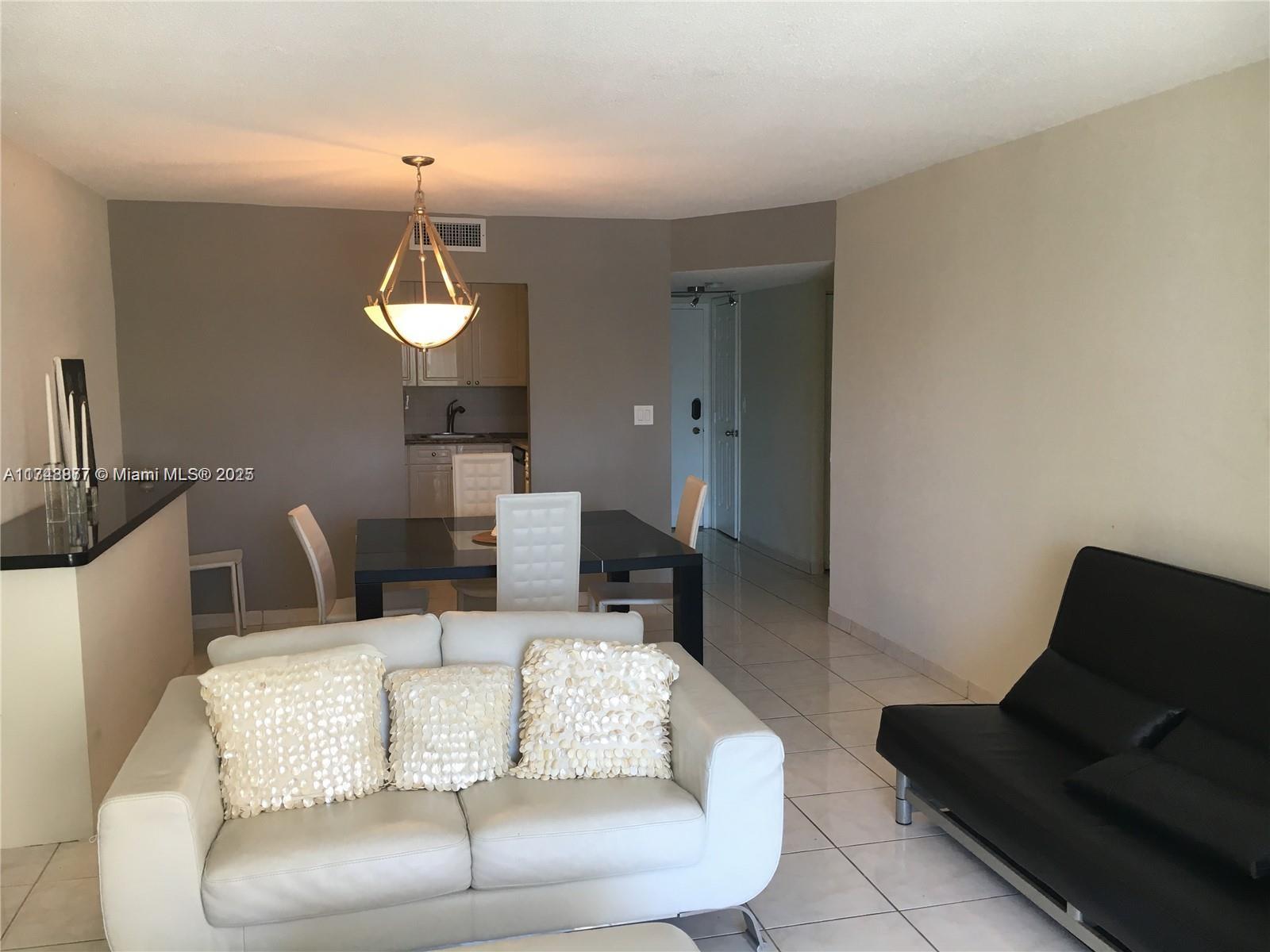 2750 Northeast 183rd Street, Unit 801 Aventura, FL 33160 - Photo 15 of 29 a living room with furniture and a lamp