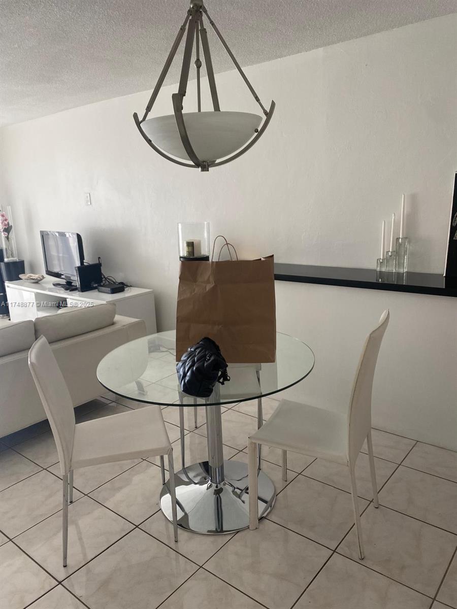 2750 Northeast 183rd Street, Unit 801 Aventura, FL 33160 - Photo 5 of 29 a living room with dining table and chairs