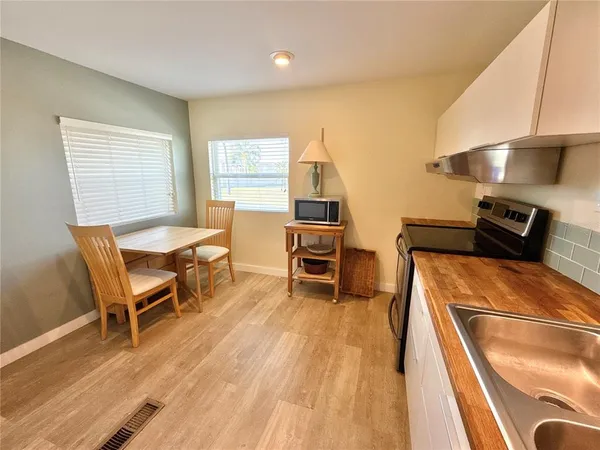 a room with wooden floor table and chairs