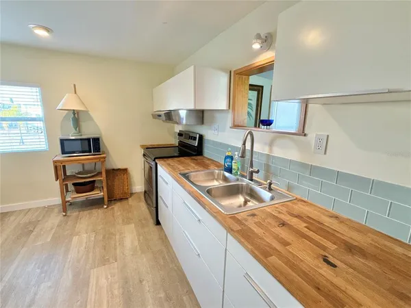 a kitchen with granite countertop a sink a counter top space appliances and cabinets