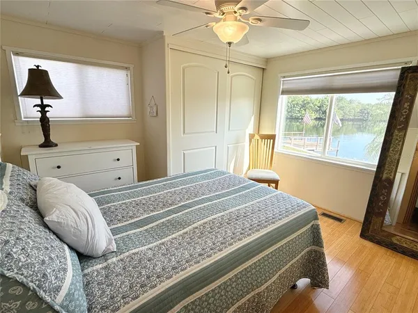 a bedroom with a bed and a flat tv screen on dresser