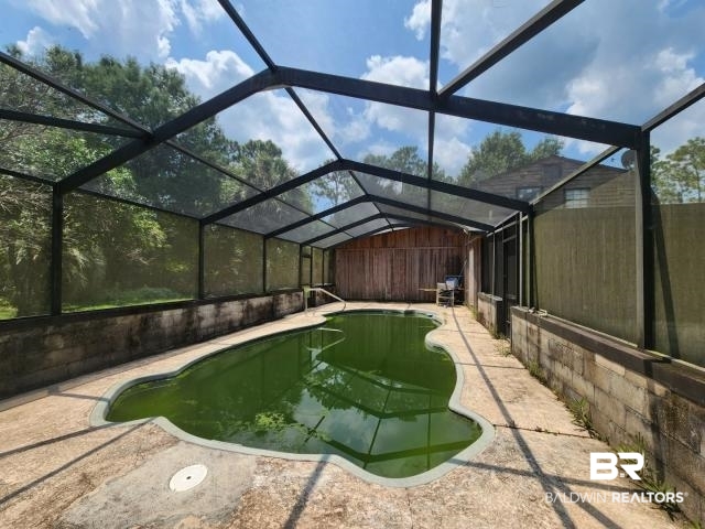 32749 Antietam Road Lillian, AL 36549 - Photo 39 of 47 View of pool featuring glass enclosure and a patio