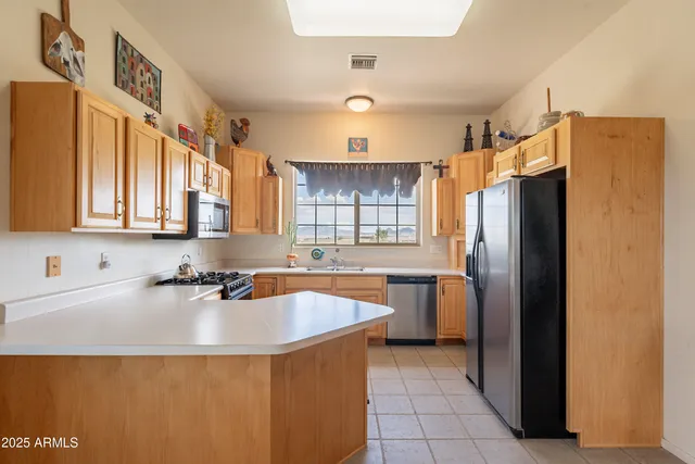 a kitchen with stainless steel appliances a sink window and cabinets