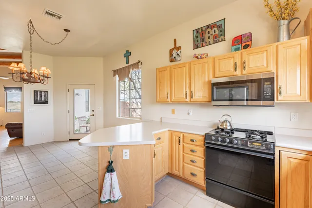 a kitchen with cabinets a window and stainless steel appliances