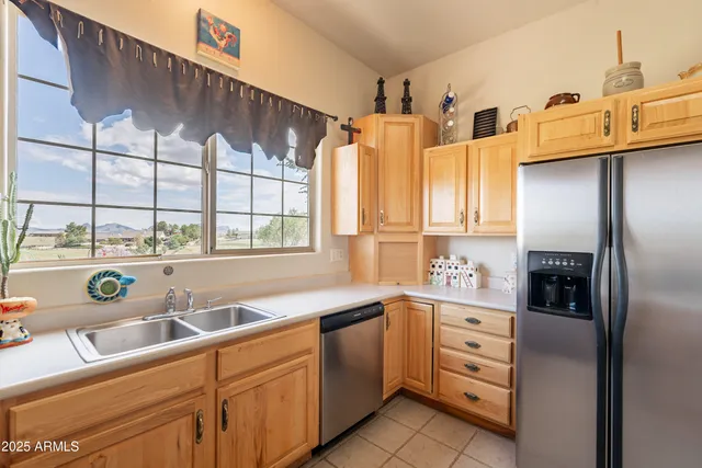 a kitchen with stainless steel appliances kitchen island granite countertop a refrigerator and cabinets