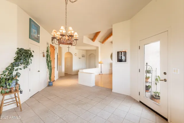 a spacious bedroom with a bed and a chandelier
