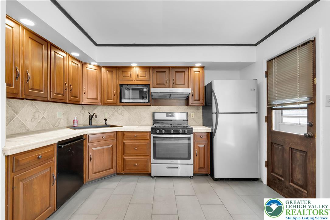 2118 6th Street Bethlehem, PA 18020 - Photo 7 of 40 a kitchen with stainless steel appliances granite countertop a refrigerator sink and stove