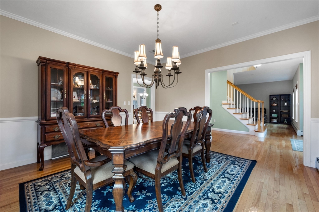 731 Samuel Drive Northbridge, MA 01588 - Photo 10 of 33 a dining room with wooden floor a chandelier a wooden table and chairs