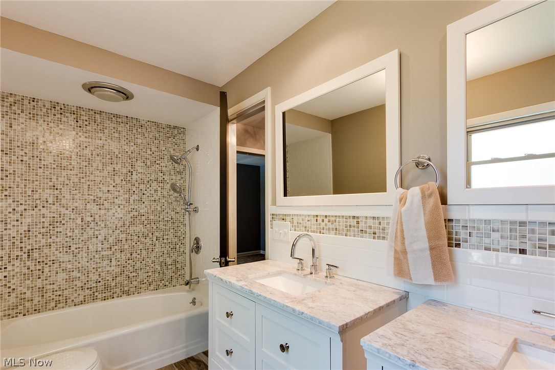 1046 Allston Road Cleveland Heights, OH 44121 - Photo 34 of 34 The master bathroom vanities have coordinating marble tops and designer faucets. The wood grained ceramic tile floor adds a feeling of warmth in this secluded bathroom. Note the full wall in the tub surround of glass mosaic tile! Stunning!