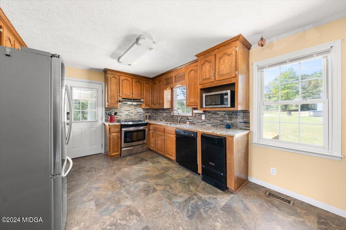3645 Tidwell Road Lizella, GA 31052 - Photo 11 of 26 a kitchen with stainless steel appliances granite countertop a refrigerator a stove a sink dishwasher a oven with a dining table and chairs