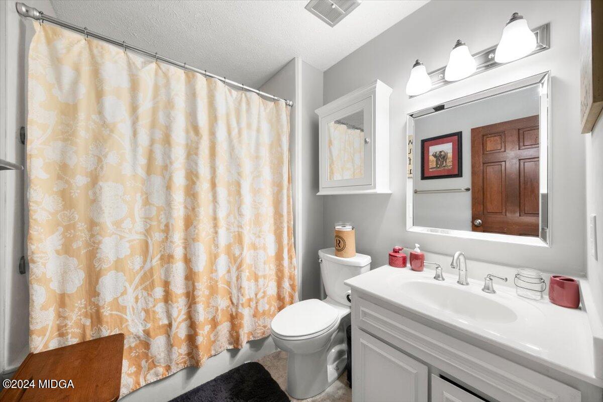 3645 Tidwell Road Lizella, GA 31052 - Photo 18 of 26 a bathroom with a white sink a toilet and a mirror